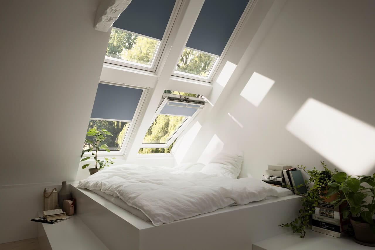 Bedroom with blue colored blackout blinds in 4 windows.